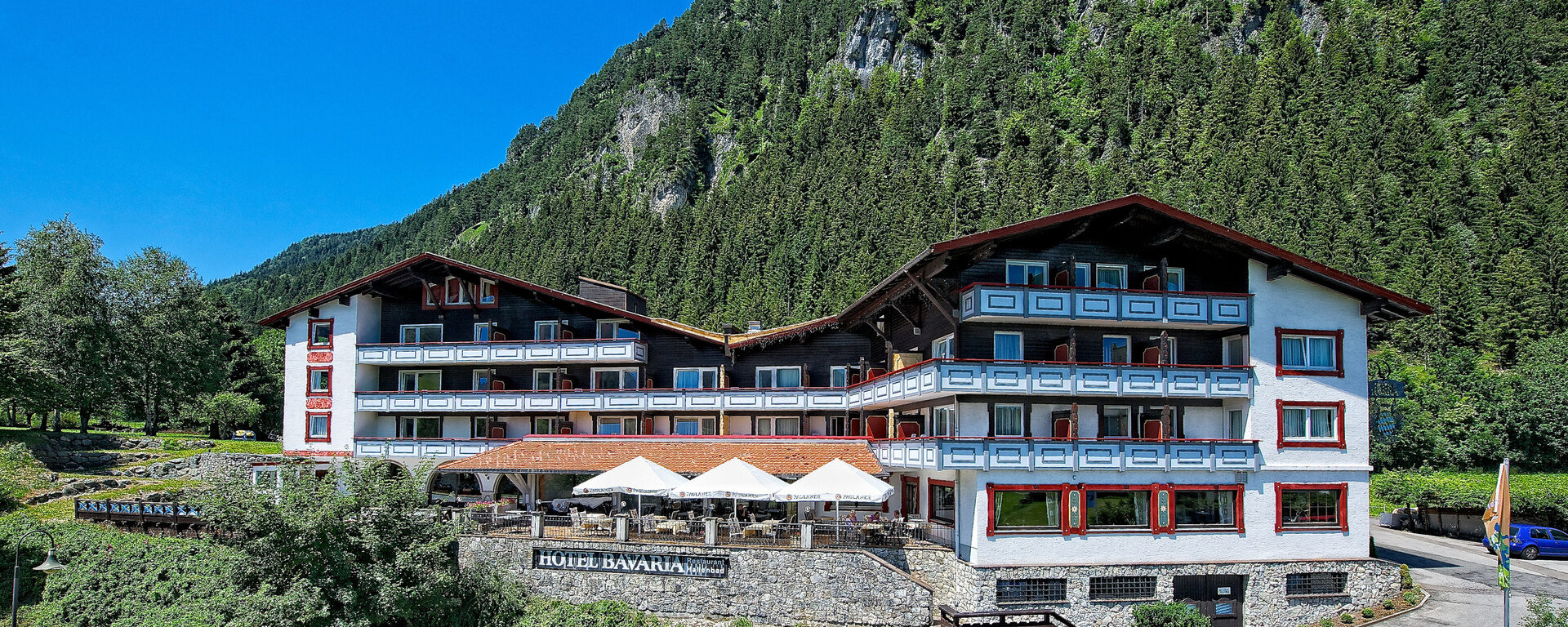 Hinter dem Hotel Bavaria in Pfronten-Dorf erhebt sich ein bewaldeter Berg
