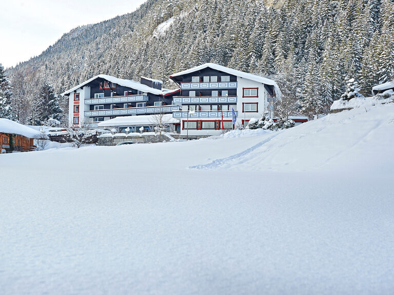 Ein verschneiter Hügel auf dem das Hotel Bavaria steht